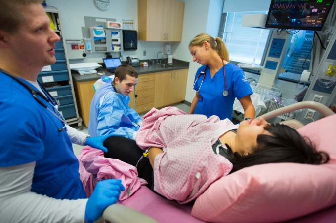 Zoom image: Nursing students participate in a birthing simulation in the Behling Human Simulation Center. 